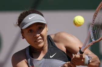 Naomi Osaka returns the ball to Patricia Maria Tig during their first round clash.