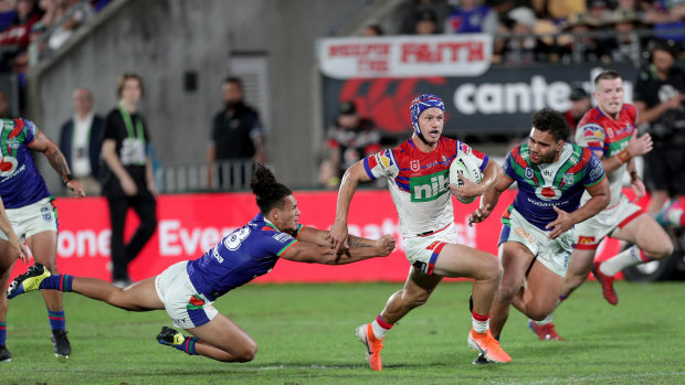 Clutching at straws: Newcastle fullback Kalyn Ponga bursts through the Warriors defence on the way to the tryline.
