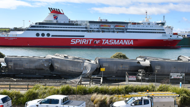 The crumpled carriages lie opposite the Spirit of Tasmania ferry.