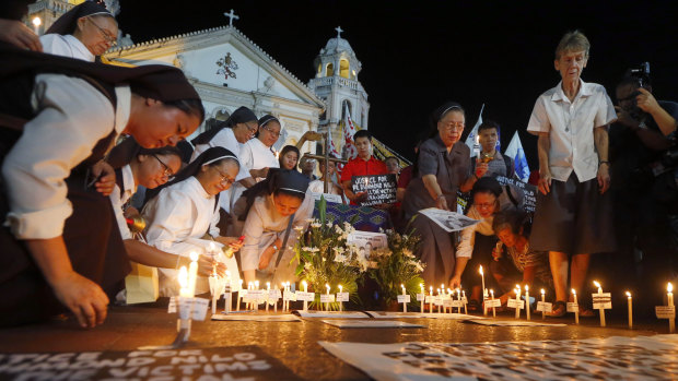 Australian nun Sister Patricia Fox, right, takes part in prayers to protest the killings of Roman Catholic priests in the Philippines. 