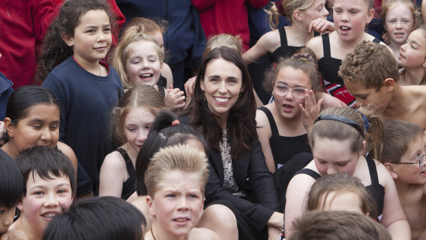 New Zealand PM Jacinda Ardern sits with the children of Spreydon West school on Friday.