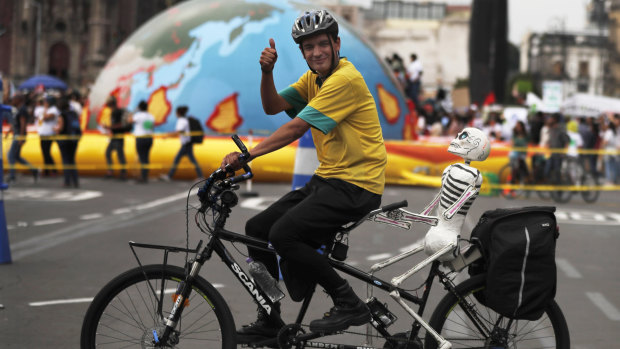 A man rides protests climate change in Mexico City on Friday, as thousands of people took the streets around the globe  in the run-up to a UN summit to demand leaders tackle the problem.