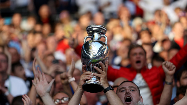 A fan holding a replica Euro 2020 Championships Trophy in London. 