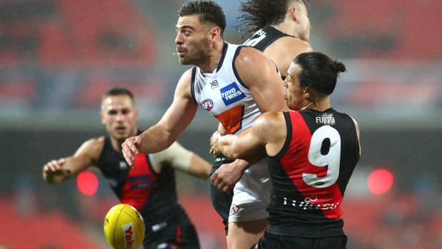 Stephen Coniglio of the Giants is tackled by Dylan Shiel of the Bombers.