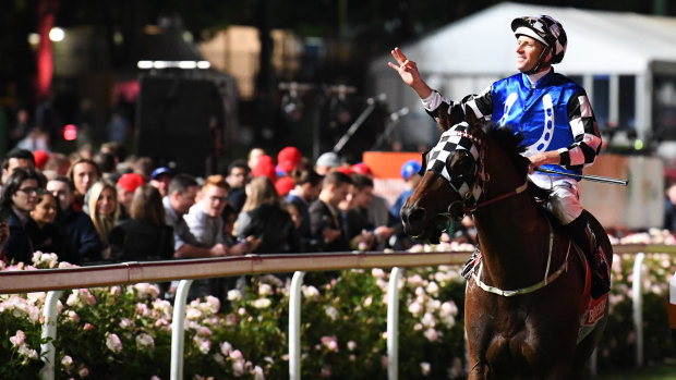 Hugh Bowman salutes the crowd. He will return the following day to pilot Winx.