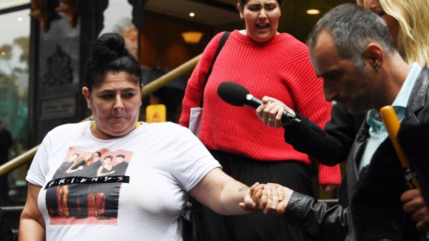 Alison Mains (left) is helped by a friend as she leaves the Downing Centre District Court in Sydney on September 18, 2019.
