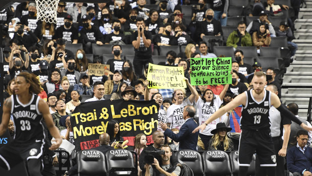 People raise signs referencing Tibet and Hong Kong during the fourth quarter of a preseason NBA basketball game between the Toronto Raptors and the Brooklyn Nets.