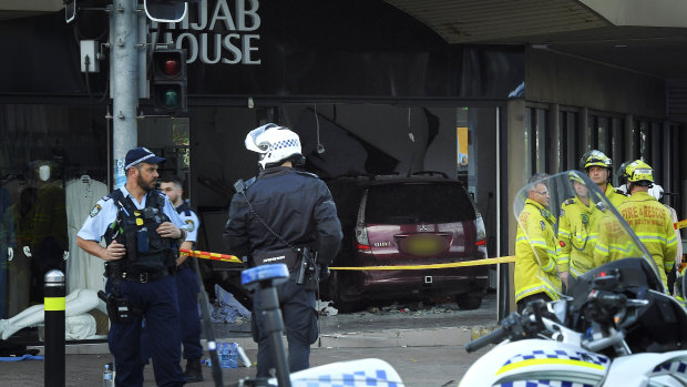 Police and emergency workers stand in front of Hijab House in Greenacre after a car drove into the shop, injuring 14 people.