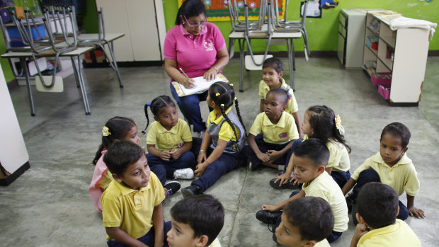 Teacher Daixy Aguero take notes as she teaches her class at a school in Caracas, Venezuela. 