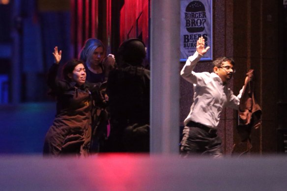 Hostages are assisted from the Lindt Chocolat Cafe in Martin Place in December 2014.