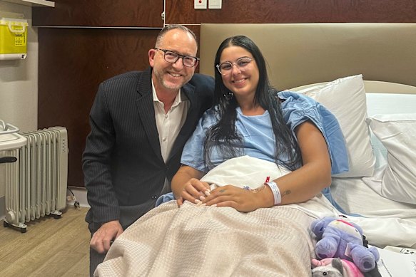 Isabelle Metaxotos poses for a photo with Dr Simon Gordon in hospital after he surgically removed her left ovary and fallopian tube in 2025.