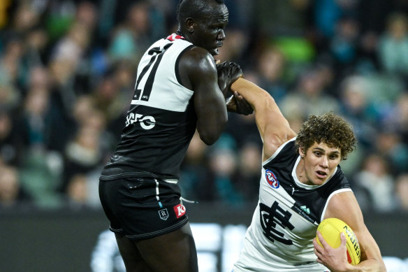 Charlie Curnow is tackled by  Aliir Aliir.