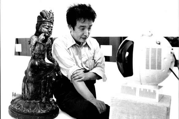 Korean video artist Nam June Paik in 1976 with a work from his <i>TV Buddha</i> series.