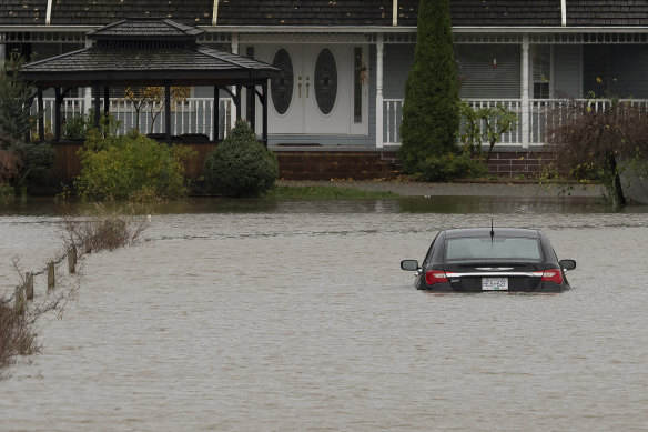 A vehicle is submerged in floodwaters along a road in Abbotsford, British Columbia.