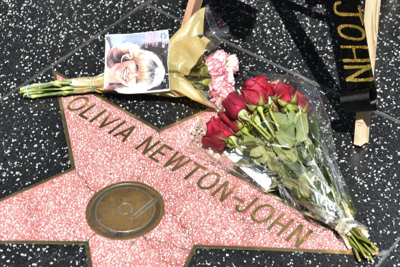 Fans leaving flowers on Olivia Newton-John’s Hollywood Walk of Fame star. 