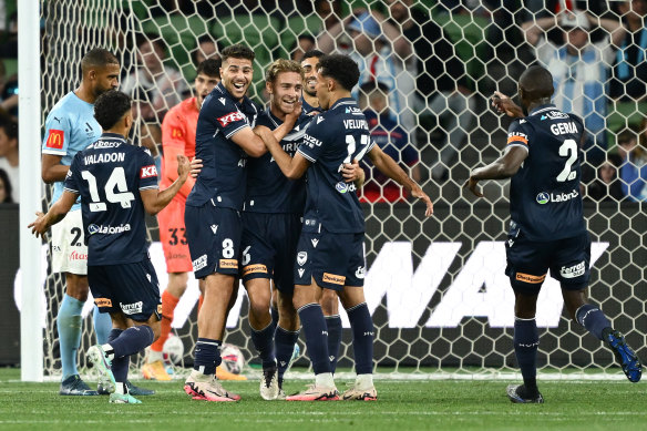 Ryan Teague celebrates Victory’s third goal with his teammates.