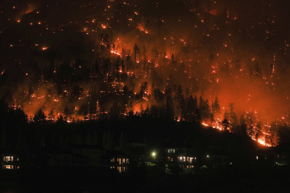 The McDougall Creek wildfire burns on the mountainside above houses in West Kelowna, B.C.