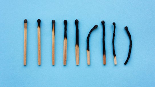 Burned matches in a row on a blue background. The concept of depression, extinction, illness, burnout, aging. View from above, flat d