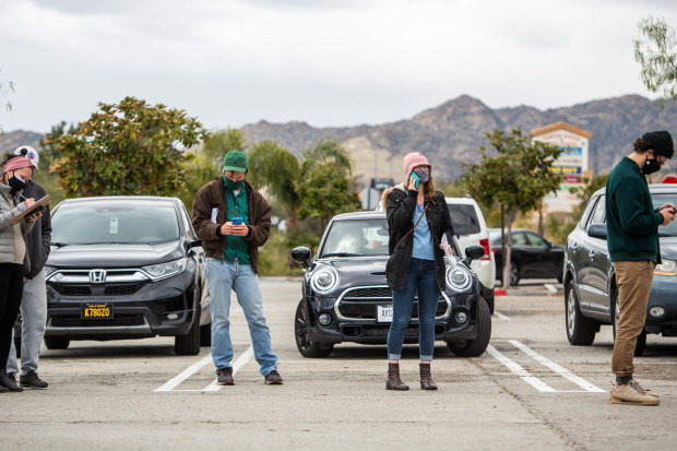 In California, people stand in a church carpark to wait for vaccines from a pop-up clinic in March. 