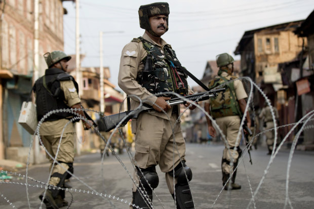 Indian paramilitary soldiers stand guard during curfew in Srinagar on August 7.