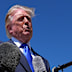 US President Donald Trump talks with reporters after an emergency inflatable slide deployed on Air Force One.