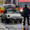Police and emergency services stand near a damaged car that drove into demonstrators marching in Munich.