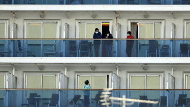 Passengers speak on balconies of the quarantined Diamond Princess cruise ship docked at a port in Yokohama, near Tokyo, Thursday, Feb. 20, 2020.