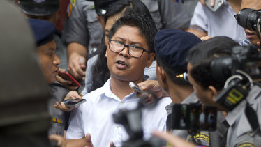 Reuters journalist Wa Lone, centre, talks to journalists as he is escorted by police when leaving the court on Monday in Yangon, Myanmar. 