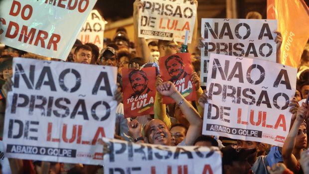 Lula supporters hold signs that read in Portuguese "No to prison for  Lula," outside the metal workers' union headquarters after the warrant was issued.