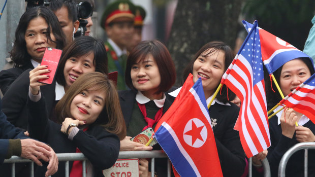 Young Vietnamese pose for a selfie outside the Hotel Melia in Hanoi while waiting for Kim Jong-un.