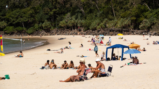 Beach-goers enjoying the sun and sand at Noosa last month.