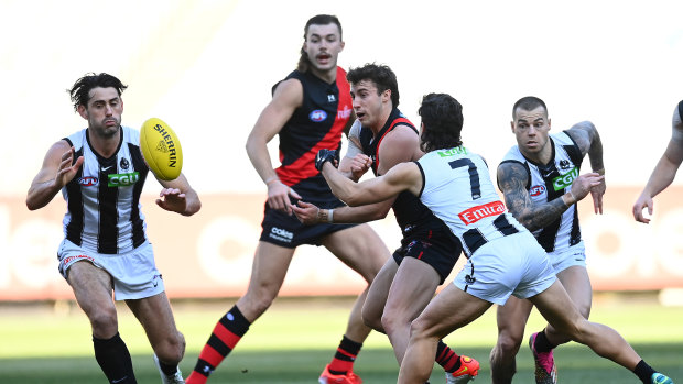 Andrew McGrath of the Bombers handballs.