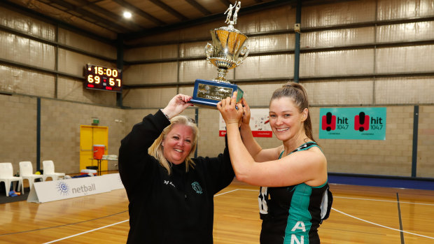 Kim Symons and Fiona Morrissey lift the State League trophy.