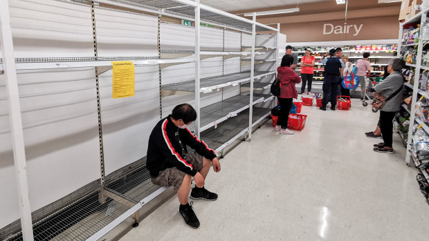 People waiting for toilet paper in supermarket aisle