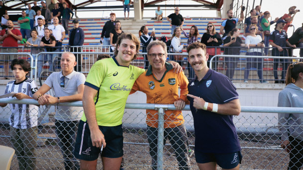 Fraser McReight and Nic White pose with a man wearing a Wallabies jersey after training at the team’s base in France.