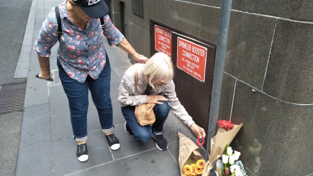 Cheryl Page and Dianne Davies left a red poppy as a tribute on Bourke Street on Saturday.