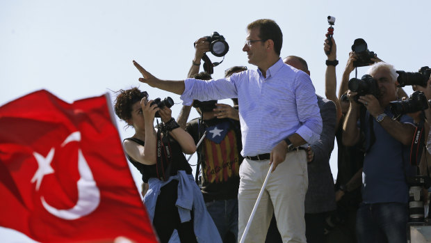 Ekrem Imamoglu, candidate of the secular opposition Republican People's Party, or CHP, waves to supporters from a boat ahead of the poll. 