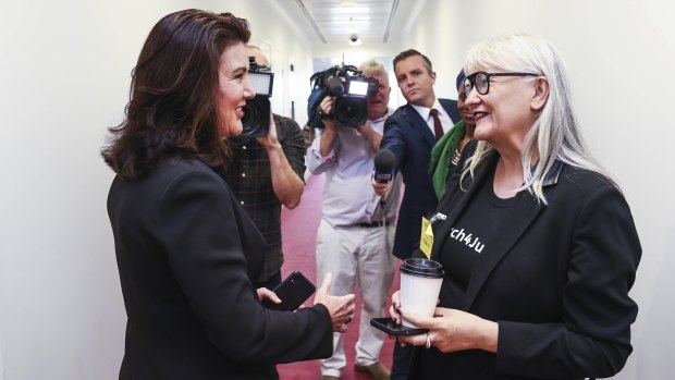 Senator Jane Hume speaks with the March 4 Justice organiser Janine Hendry in a hallway at Parliament House.