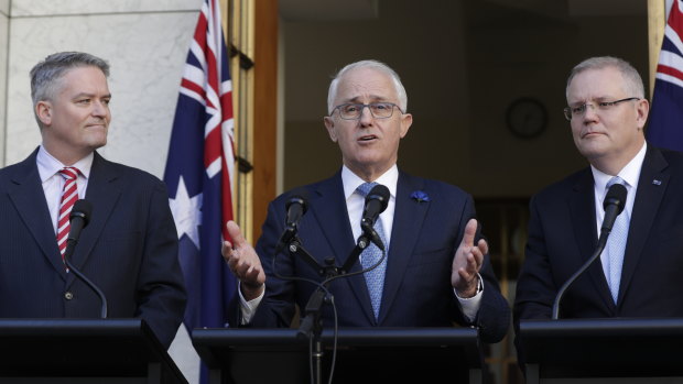 Prime Minister Malcolm Turnbull, with Finance Minister Mathias Cormann and Treasurer Scott Morrison, speaks to the media following the passage of the tax legislation through the Senate. 