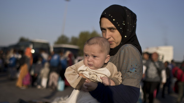 Nermi Zeitoun, 19, from Idlib, Syria, holds her three-month-old son after they disembark   at the port of Piraeus on Tuesday. Nermi was one of 400 migrants deemed vulnerable and removed from the Moria camp on Lesbos.