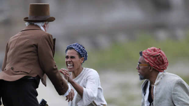 Slaves attack a slave owner during a performance reenacting the largest slave rebellion in US history.