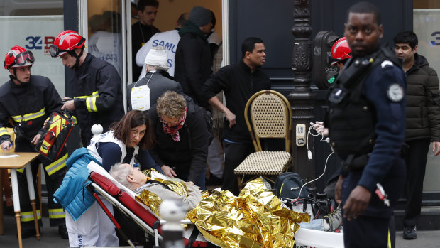 Medical staff and firefighters tend to a wounded man at the scene of a gas leak explosion.