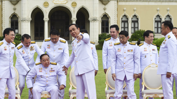 Reflecting the culture: Thai Prime Minister Prayut Chan-o-cha assists his Deputy Prime Minister General Prawit Wongsuwan during a group photo after cabinet reshuffle at Government House in Bangkok last month.