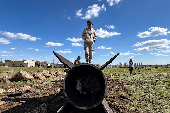 Syrian children stand on the wreckage of an Iranian rocket reportedly intercepted by Israeli forces.