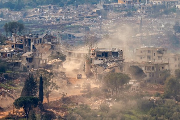 Tanques e veículos israelenses passam por casas destruídas no sul do Líbano no sábado.