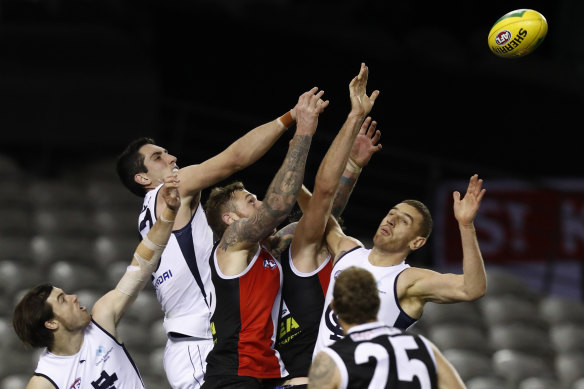 Jacob Weitering of the Blues and Tim Membrey fly for the ball.