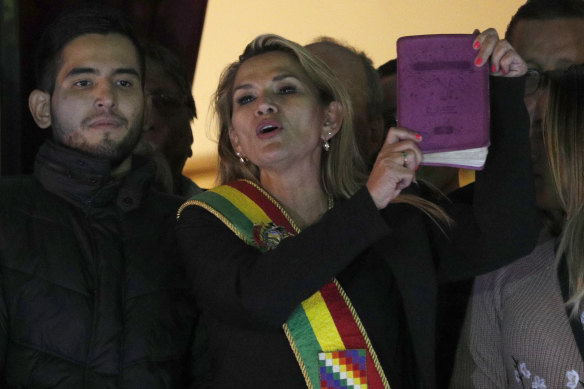 Jeanine Anez, wearing the Presidential sash and holding a Bible, addresses a crowd from the balcony of the Quemado palace after she declared herself interim president of Bolivia in 2019. 