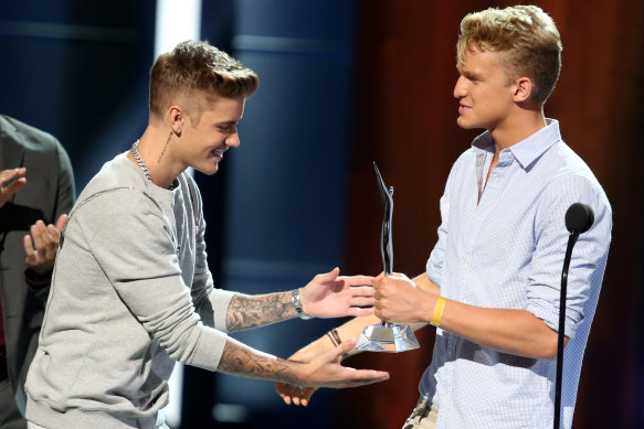 Justin Bieber presents Cody Simpson with a gong at the 2014 Young Hollywood Awards.