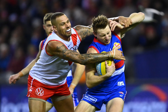 Lance Franklin tackles the Bulldogs’ Bailey Dale during Sydney’s win on Sunday.