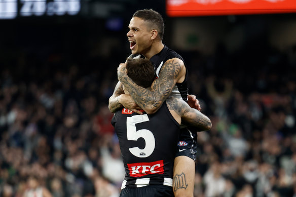 Jamie Elliott (left) and Bobby Hill of the Magpies celebrate a goal.